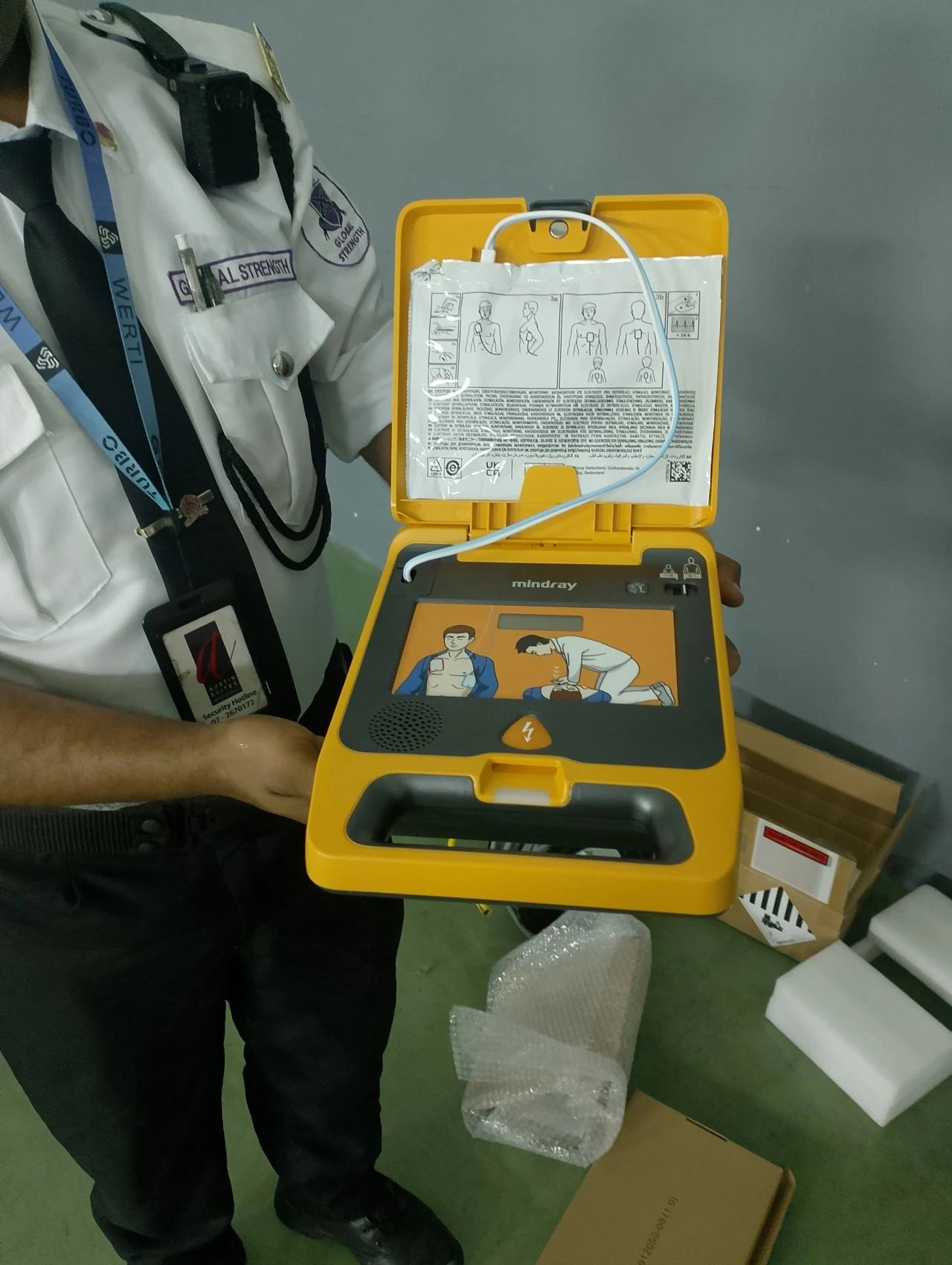 Security personnel learning how to use an AED during practical training